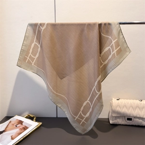 Close-up of elegant champagne silk scarf featuring a classic white chain pattern