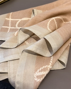 Close-up of herringbone weave texture and rope pattern on beige linen-feel scarf