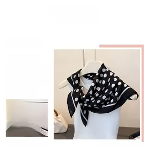 Detailed texture of black and white polka dot square scarf with delicate white hemmed edges