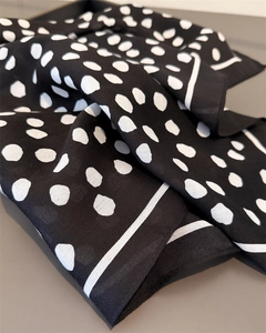 Detailed macro view of black and white polka dot silk scarf with twill texture weave