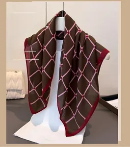 Detail of thin brown scarf featuring pink diamond patterns and red hearts on a hanger
