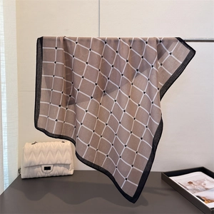 Khaki plaid square scarf with heart patterns and black border on a metal stand