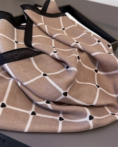 Detail of khaki square scarf with white grid pattern and small black heart accents