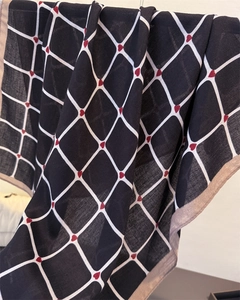 Detail showing red heart patterns on black diamond plaid scarf fabric texture