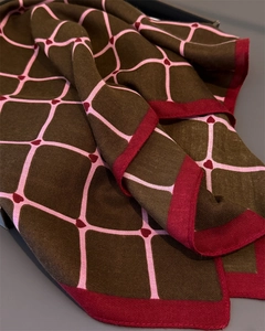 Detail of herringbone weave scarf featuring pink grids and deep red heart patterns