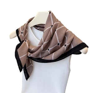 Khaki plaid scarf with small heart patterns and black border on white mannequin
