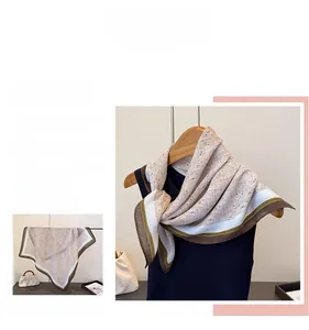 Detail of herringbone linen-textured scarf featuring beige print and green contrast borders