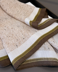 Detail of oatmeal herringbone scarf featuring green geometric patterns and soft knit texture