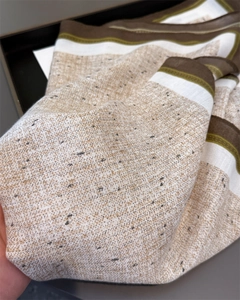Close-up of herringbone texture scarf showing thick wool-like fabric in brown and beige