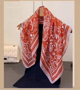 Detail eines Paisley-Schals in Orange auf Holzkleiderbügel mit leichter Stoffstruktur