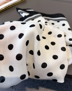 Detail of classic black and white polka dot scarf featuring twill texture and silky luster