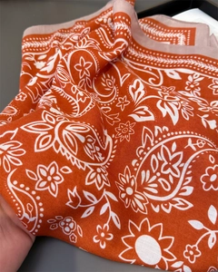 Detailansicht der orangefarbenen Paisley- und Blumenmuster auf dem leichten Baumwoll-Leinen-Schal