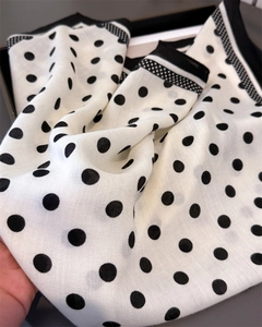 Detailed view of polka dot herringbone twill silk scarf with contrast edge piping
