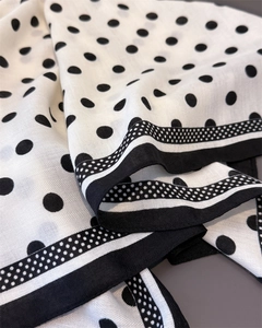 Close-up of elegant white polka dot cotton linen scarf with French stripe pattern