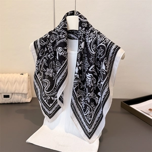 Detailansicht des Paisley- und Blumenmusters auf leichtem schwarz-weißem Tuch