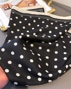 Detailed view of polka dot pattern on soft silk scarf with stylish white contrast borders