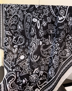 Detailansicht der Paisley- und Blumenmuster auf leichtem schwarz-weißem Schalstoff