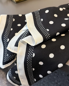 Close-up of black and white polka dot scarf featuring twill texture and wide borders