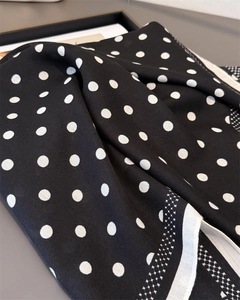 Detail of polka dot pattern on soft twill fabric scarf with white contrast piping