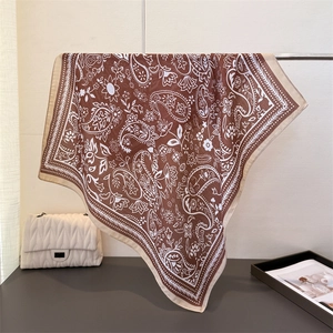 Detail eines braunen Seidenschals mit Paisley-Muster an einem Metallständer