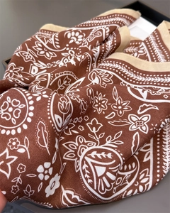 Detailaufnahme des Retro-Paisley-Musters auf dem strukturierten quadratischen Schal