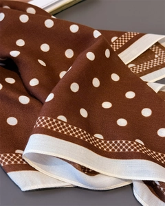 Detailed view of coffee brown polka dot silk scarf with elegant geometric border