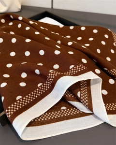 Detail of soft brown polka dot silk scarf with fine mesh geometric border and elegant drape