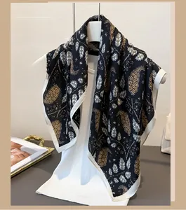Detail of elegant black paisley scarf with white border on minimalist hanger display