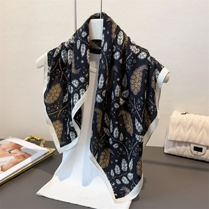 Luxurious herringbone print silk scarf in paisley pattern on an elegant mannequin