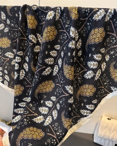 Detail of herringbone cotton-linen scarf with yellow leaf patterns and white rolled edges