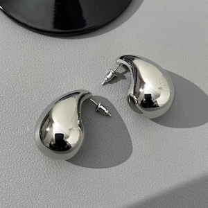 Minimalist silver water drop earrings with high-polished metallic finish on leather