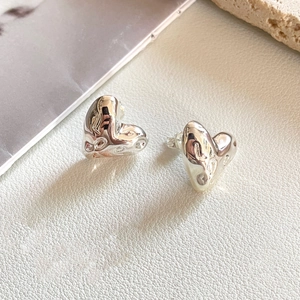 Lava texture heart-shaped silver earrings for women on elegant white leather background
