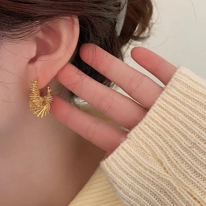 Irregular spring-style golden hoop earrings with unique metallic winding design for women