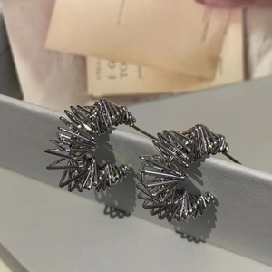 Detail of silver spiral wire earrings with unique geometric C-shape industrial design