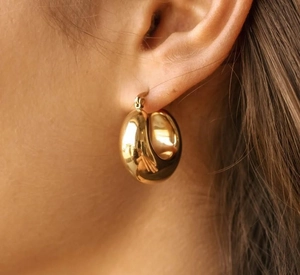 Detailed close-up of 18K gold-plated teardrop earrings with a high-polished mirror finish