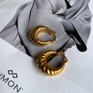 Vue détaillée des boucles d'oreilles croissant plaquées or 18K avec texture de fil torsadé