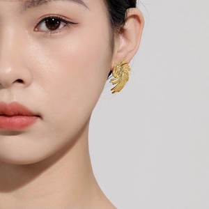 Elegance 18K gold plated woven spiral fan stud earrings on model with high gloss finish