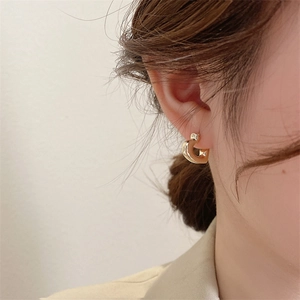 Close-up of elegant gold heart-shaped hoop earrings worn for a minimalist chic style