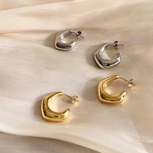 Créoles en forme de C en or 18 carats et argent sur un tissu en soie élégant