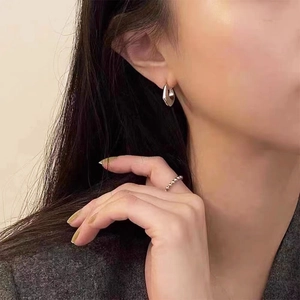 Boucles d'oreilles minimalistes en argent en forme de U avec finition polie sur modèle