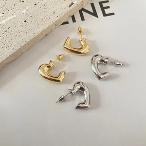 Minimalist gold and silver heart-shaped stud earrings in a high-polished metallic finish