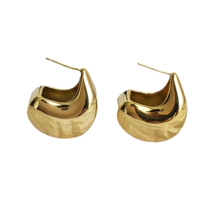 Polished 18K gold-plated teardrop horseshoe earrings with hammered texture on white background