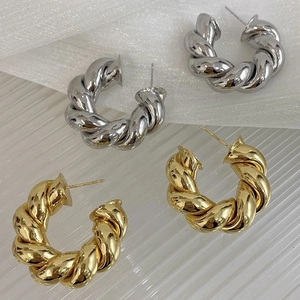 Set of gold and silver chunky twisted C-hoop earrings with textured spiral design
