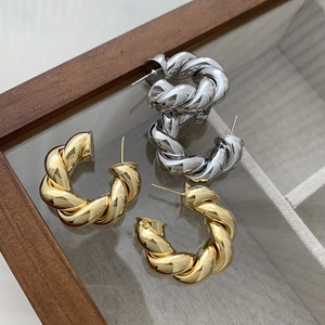 Minimalist chunky twisted hoop earrings in gold and silver finish for a modern metal style
