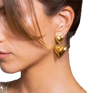 Nahaufnahme von doppelten Herzohrringen mit 18K Goldbeschichtung an einem Model