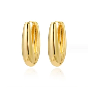 Macro view of chunky golden teardrop earrings with a polished mirror finish surface