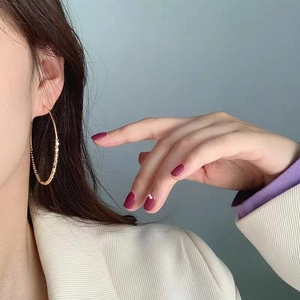 Große goldene Creolen für Damen mit strukturierter Perlenoberfläche in minimalistischem Stil