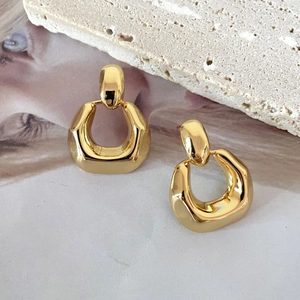 Macro shot of 18K gold plated geometric U-shaped earrings with a high-polished mirror finish