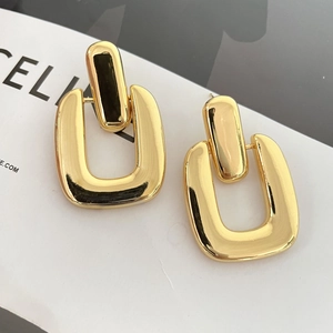 Detail of 18K gold-plated earrings featuring nested geometric rectangular shapes with high polish