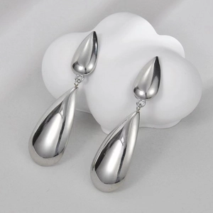 Detailed close-up of silver teardrop dangle earrings with a mirror polished finish